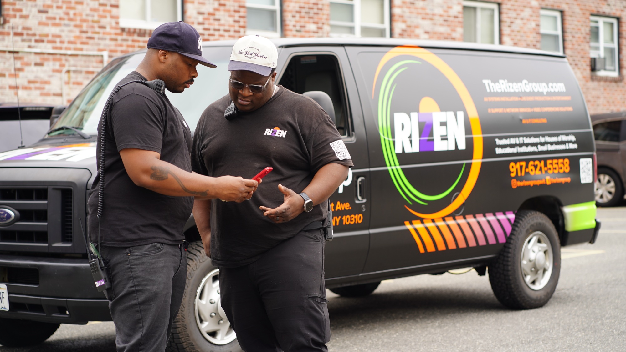 Robb and Matt reviewing project information beside The Rizen Group service van